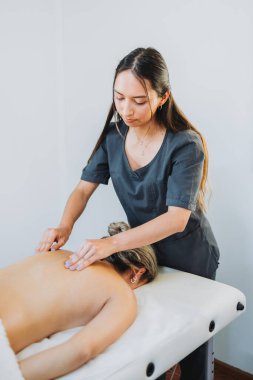 Kadın bir hastaya sırt ve boyun masajı yapan bir terapist. Sağlık merkezi kaplıcası. Cilt bakımı.