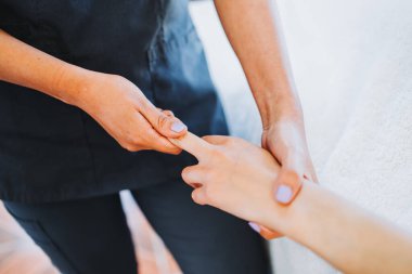 Kadın bir hastaya el ve parmak masajı yapan tanınmamış bir terapist. Sağlık merkezi kaplıcası. Cilt bakımı.
