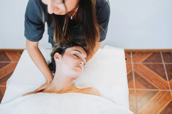 Terapeuta haciendo un masaje en el cuello a una paciente femenina inclinada hacia la cabeza. Spa centro de bienestar. Cuidado de la piel. —  Fotos de Stock