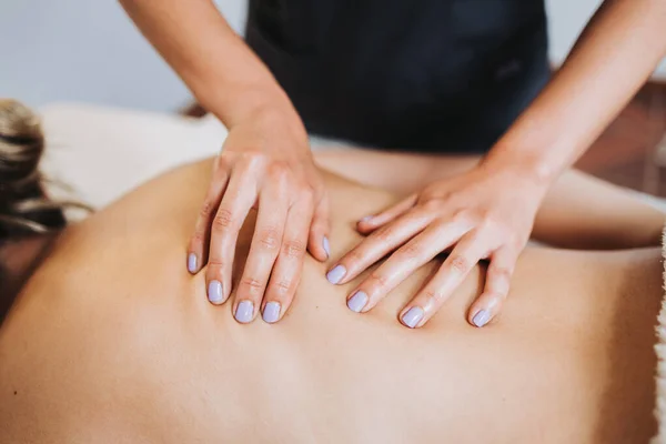 Terapeuta irreconocible haciendo masaje de espalda y columna vertebral a una paciente femenina. Relajante y desestresante — Foto de Stock