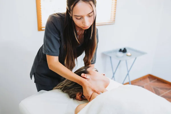 Terapeuta haciendo un masaje en el cuello a una paciente femenina inclinada hacia la cabeza. Spa centro de bienestar. Cuidado de la piel. —  Fotos de Stock