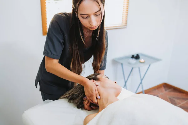Terapeuta haciendo un masaje en el cuello a una paciente femenina inclinada hacia la cabeza. Relajante y desestresante —  Fotos de Stock