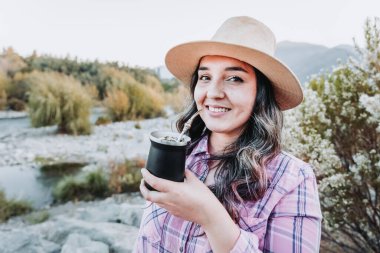 Şapkalı genç, beyaz bir kadın. Sonbahar havasında, doğal ortamda içki arkadaşı..