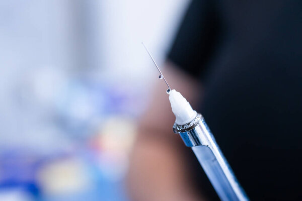 Dentists hands preparing syringe for giving dental anesthesia to her patient. Selective focus.