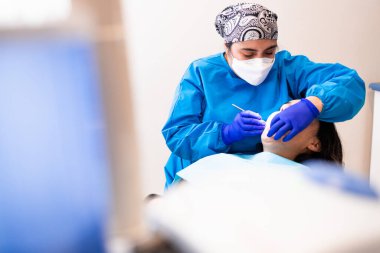 Dişçi bir dişçiye ağız aynası ve kazıcı kullanarak rutin bir diş muayenesi yapıyor. Diş bakımı. Yatay olarak. Boşluğu kopyala