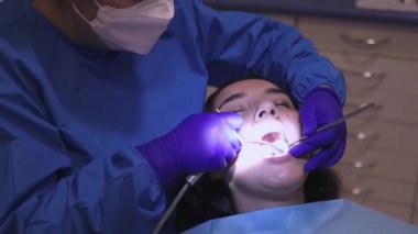 Kadın dişçi, rutin bir diş muayenesi için bir motor matkabı kullanıyor. - Evet. Diş bakımı. Yatay olarak. Boşluğu kopyala