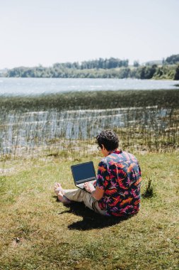 Genç latin adam gölden uzaktan kumandayla iş yapıyor. Telesekreter konsepti. Yüksek kalite fotoğraf