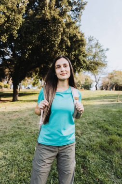 Geleceğe bakıyorum. Aquamarina tişörtü giyen genç bir kız kampüsün ufkuna bakıyor. Yüksek kalite fotoğraf