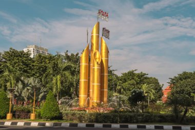 Noktalı bambu heykeli (anıt bambu akıntısı) Surabaya şehir sokağının ortasında yer alan fıskiyeler ve ağaçlarla çevrilidir. Gündüz çekilmiş.