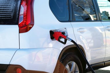 Benzin ya da benzin doldurma sırasında arabada bırakılan yakıt tabancası dondurucu kış mevsiminde istasyonda duruyor..