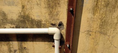 Demir paslı çamaşır makinesi ve cıvatalı duvar.