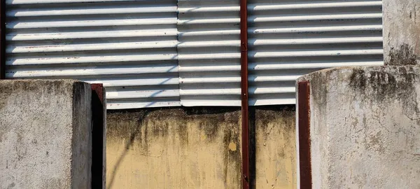 Demir paslı çamaşır makinesi ve cıvatalı duvar.