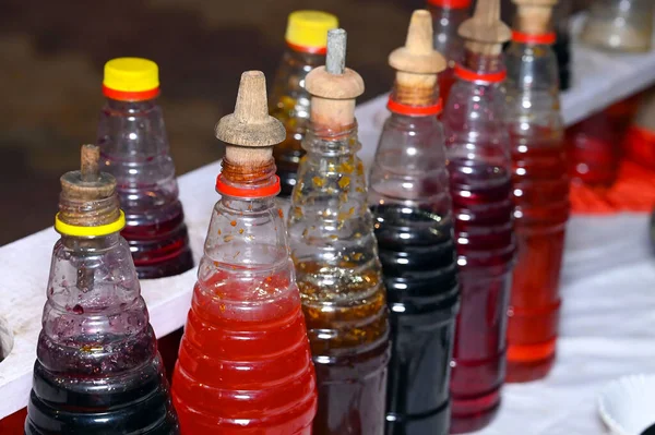 Renkli yaz içecekleri yapmak için şerbetli plastik şişeler.