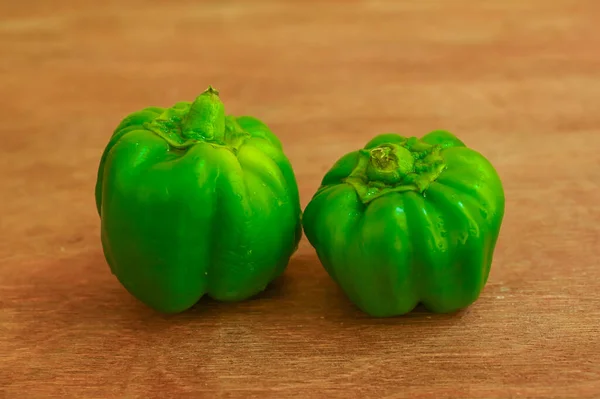 Ahşap arka planda taze yeşil dolma biber (capsicum)
