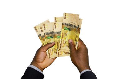 Siyah elli takım elbiseli, elinde 3 boyutlu Ugandalı şilinler var.