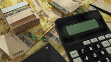 Ugandan shilling notes spread out with a calculator, pen and notebook. 3d rendering