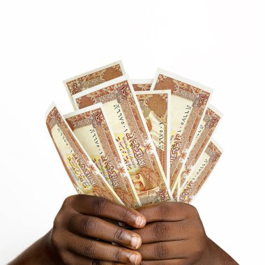 Black hands holding 3D rendered 100 Omani Baisa notes. closeup of Hands holding Oman currency notes
