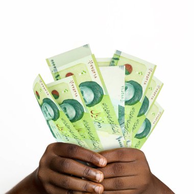 Black hands holding 3D rendered Iranian rial notes. closeup of Hands holding Iranian currency notes