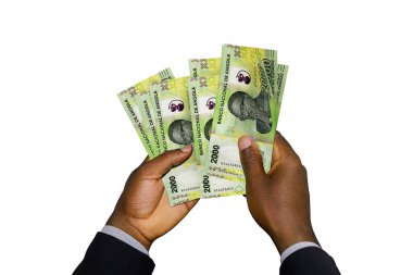 Siyah elli takım elbiseli, elinde 3 boyutlu Angolan Kwanza notları var.