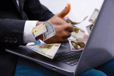 Nigerian naira notes coming out of laptop with Business man giving thumbs up, Financial concept. Make money on the Internet, working with a laptop