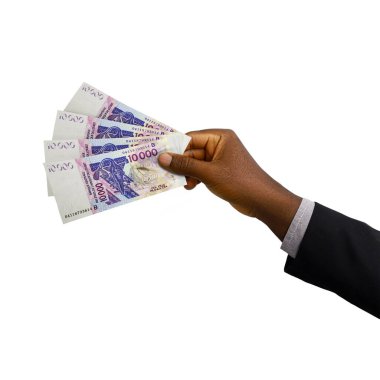 Black Hand with suit holding 3D rendered 10000 West African CFA Franc notes isolated on white background. Beninese, Burkinabe, Bissau-Guinean, Ivorian, Malian, Nigerien, Senegalese, Togolese