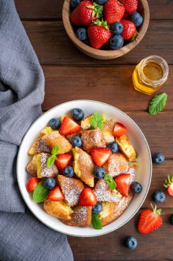 Kaiserschmarrn - koyu ahşap zemin üzerinde taze böğürtlen ve pudra şekerli geleneksel Avustralya krep tatlısı. Güzel kahvaltı. Boşluğu kopyala