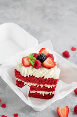 Kırmızı kadife bento keki. Gri beton arka planda, beslenme çantasında küçük bir pasta. Sevgililer günü pastası. Asya yemekleri trendi. Her bayram için güzel bir hediye. Boşluğu kopyala