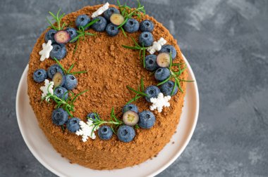Taze yaban mersinli, biberiyeli ve kar taneli çikolatalı pasta beyaz bir standın üzerinde. Noel ve yeni yıl için pasta. seçici odak.
