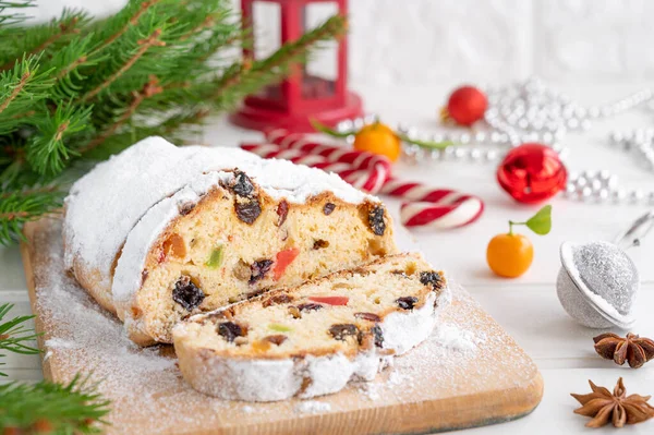 Kurumuş meyveler ve beyaz ahşap arka planda bir tahtaya pudra şekerle süslenmiş bir Noel. Boşluğu kopyala
