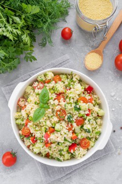 Tabbouleh salatası. Taze sebzeli kuskus salatası ve gri beton arka planda bir kasede taze bitkiler. Boşluğu kopyala
