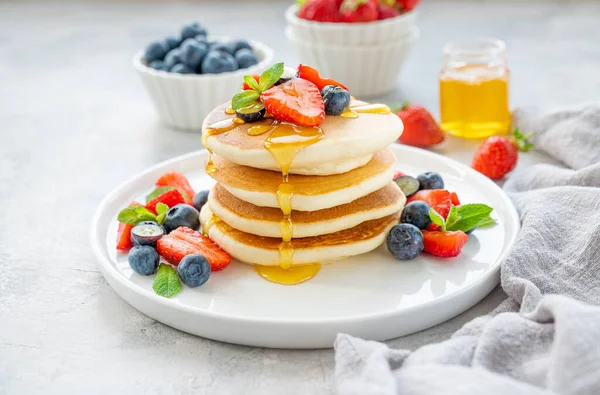 Una Pila Deliciosos Panqueques Esponjosos Con Bayas Miel Plato Blanco — Foto de Stock