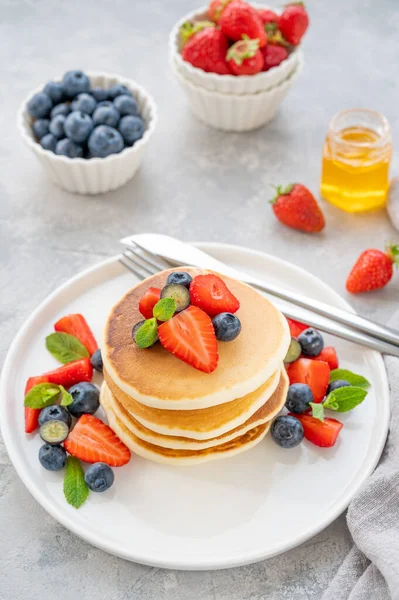 Una Pila Deliciosos Panqueques Esponjosos Con Bayas Miel Plato Blanco — Foto de Stock