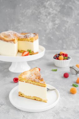 Geleneksel Polonya pastası Karpatka gri beton arka planda. Üzerine taze böğürtlen ve pudra şekerli krema ve choux hamur pastası. Karpatya pastası. Boşluğu kopyala