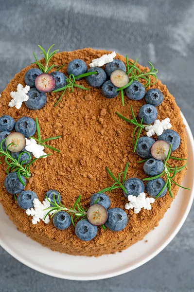 Taze yaban mersinli, biberiyeli ve kar taneli çikolatalı pasta beyaz bir standın üzerinde. Noel ve yeni yıl için pasta. seçici odak.