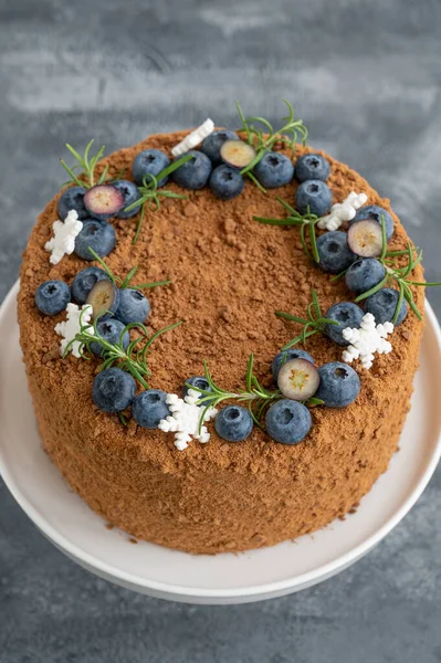 Taze yaban mersinli, biberiyeli ve kar taneli çikolatalı pasta beyaz bir standın üzerinde. Noel ve yeni yıl için pasta. seçici odak.