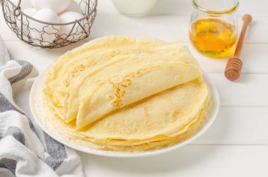 Geleneksel ince krep yığını ya da beyaz ahşap arka planda ballı krep ve ekşi krema. Maslenitsa için yemek. Boşluğu kopyala