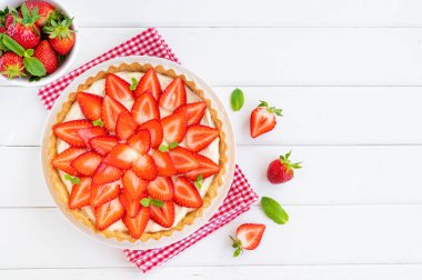 Beyaz ahşap arka planda kremalı çilekli turta. Boşluğu kopyala