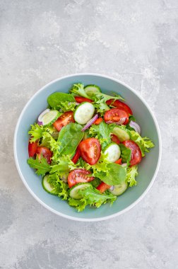 Taze sebzeli salata ve çimento kaplı bir kasede peynir. Yunan salatası, vejetaryen yemeği. Üst görünüm