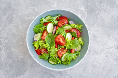 Taze sebzeli salata ve çimento kaplı bir kasede peynir. Yunan salatası, vejetaryen yemeği. Üst görünüm