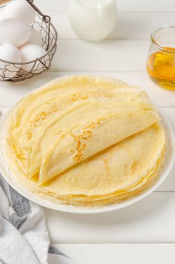 Geleneksel ince krep yığını ya da beyaz ahşap arka planda ballı krep ve ekşi krema. Maslenitsa için yemek. Boşluğu kopyala