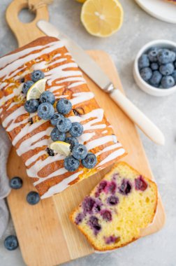 Limon kremalı limonlu yaban mersinli pasta ve tahtada gri beton arka planda bir fincan çayla taze böğürtlen. Seçici odaklanma. Boşluğu kopyala