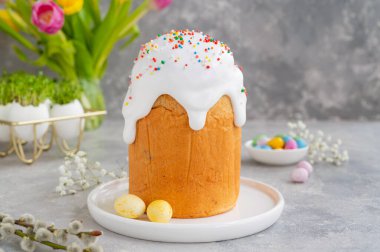 Paskalya kompozisyonu. Geleneksel Ukrayna Paskalya pastası - gri beton arka planda şekerli ve renkli şekerli Kulich. Paska Paskalya Ekmeği. Seçici odak