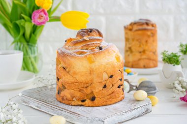 Paskalya kompozisyonu. Geleneksel Rus ve Ukrayna Paskalya pastası - Cruffin, Kraffin veya beyaz ahşap arka planda çikolatalı ve şekerli meyveli Kulich. Paska Paskalya Ekmeği. Seçici odaklanma. Boşluğu kopyala.
