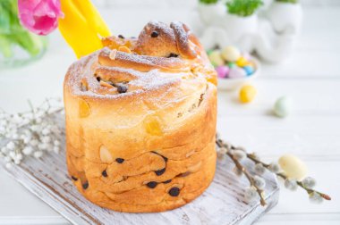 Paskalya kompozisyonu. Geleneksel Rus ve Ukrayna Paskalya pastası - Cruffin, Kraffin veya beyaz ahşap arka planda çikolatalı ve şekerli meyveli Kulich. Paska Paskalya Ekmeği. Seçici odaklanma. Boşluğu kopyala.