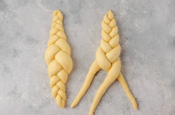 Açık gri arka planda bir somun çiğ Yahudi ekmeği. Üst görünüm, alanı kopyala