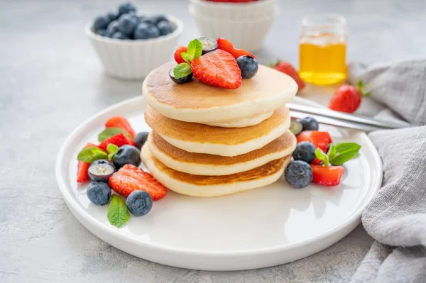 Una Pila Deliciosos Panqueques Esponjosos Con Bayas Miel Plato Blanco — Foto de Stock