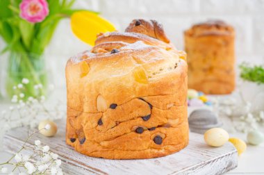 Paskalya kompozisyonu. Geleneksel Rus ve Ukrayna Paskalya pastası - Cruffin, Kraffin veya beyaz ahşap arka planda çikolatalı ve şekerli meyveli Kulich. Paska Paskalya Ekmeği. Seçici odaklanma. Boşluğu kopyala.