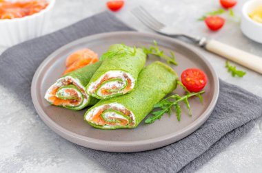 Yeşil ıspanaklı krep ya da füme somon ve gri arka planda yumuşak peynirli krep. Boşluğu kopyala