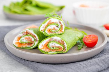 Yeşil ıspanaklı krep ya da füme somon ve gri arka planda yumuşak peynirli krep. Boşluğu kopyala