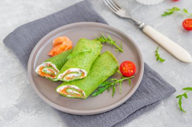 Yeşil ıspanaklı krep ya da füme somon ve gri arka planda yumuşak peynirli krep. Boşluğu kopyala